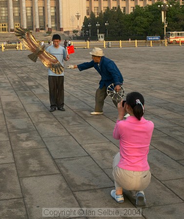 Tourists photographing each other with kite, Tiannanmen Square, Beijing
