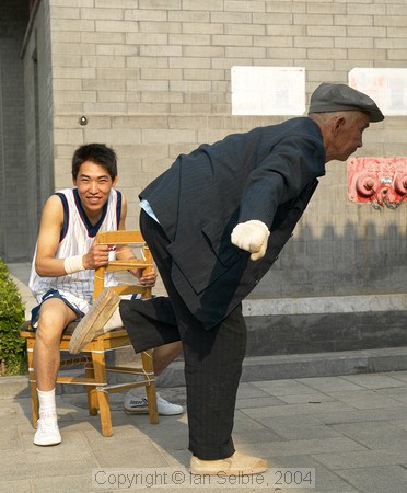 Old man demonstrating that he still flexible, Gardens of the Forbidden City, Beijing