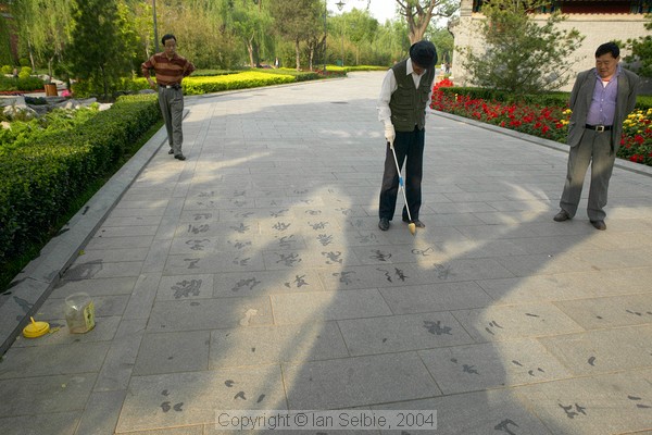 Non-permanent art - calligraphy using water on the paving stones, Gardens of the Forbidden City, Beijing