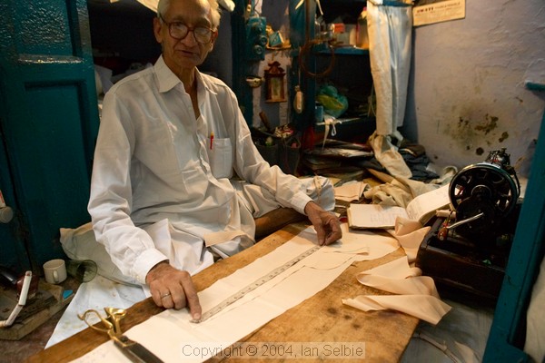 Old man working in his tiny taylor's shop, Old Delhi