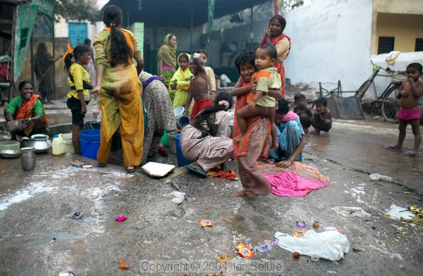 Women and children at the village water pump in the street market near the Tomb of Nizammudin, Delhi