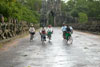 Cyclists coming through the south gate of Angkor Thom and across the Rainbow Bridge