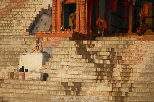 A sadhu sits above the river soon after sunrise