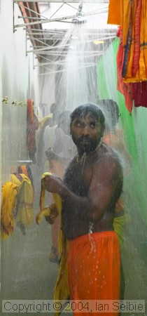 Celebrant showering after the Thimithi (fire walking) ceremony, Singapore 2003