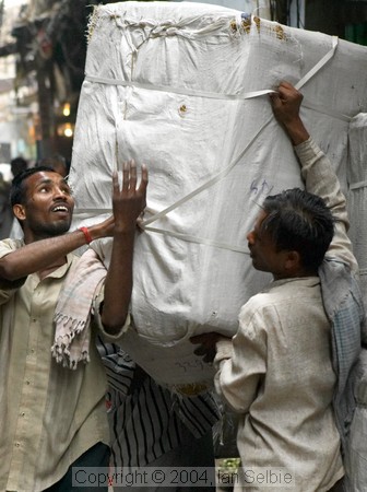 Two man carrying a huge load, Old Delhi