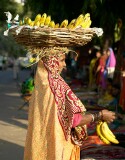 Woman selling bananas from a basket on her head at the textiles market