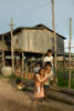 Children by stilt house on the lake