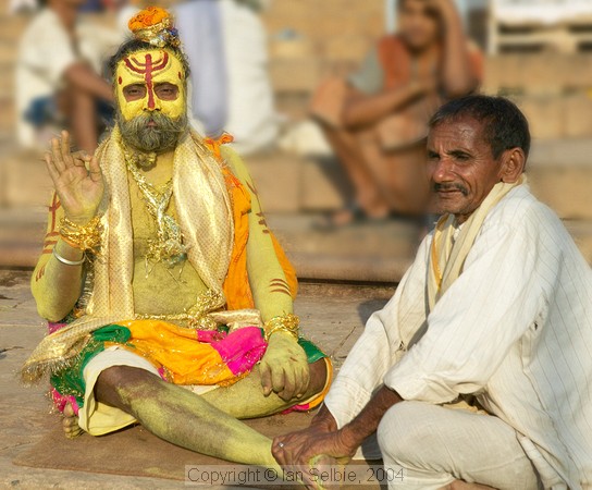 The Ganges river, Varanasi - a "sadhu" - most likely a business proposition rather than a holy mission, gets a foot massage.   Even sadhus get sore feet?