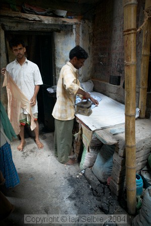 Ironing the clothes the old fashioned way near the Dhobi (laundry) Ghat