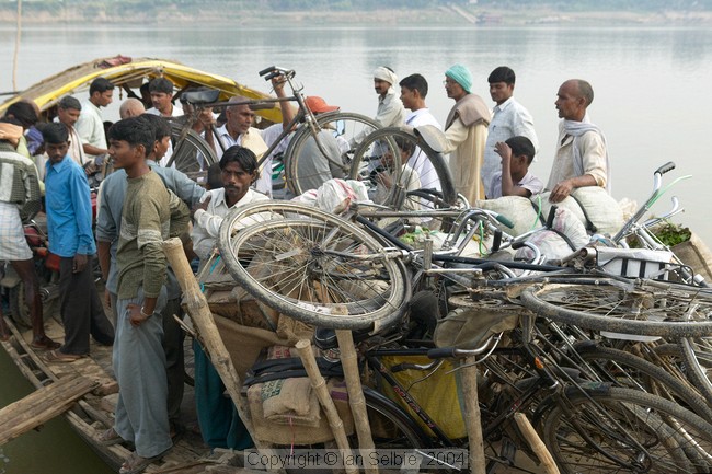 Further up the Ganges from Varanasi a river ferry is loaded up with people, bicycles, motorcycles, goods and animals